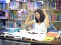 Image: Distressed student surrounded by books